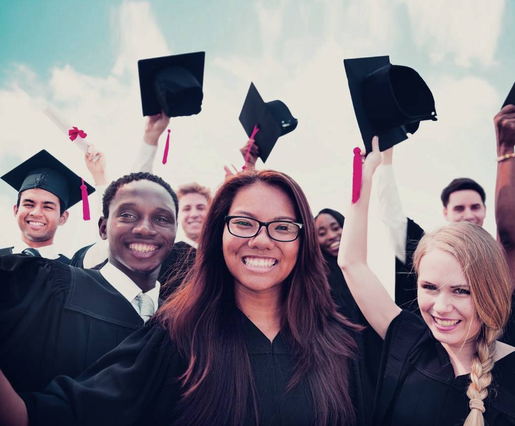 A group of people in graduation attire holding their hats.