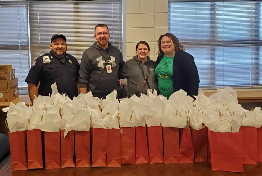 A group of people standing next to bags.