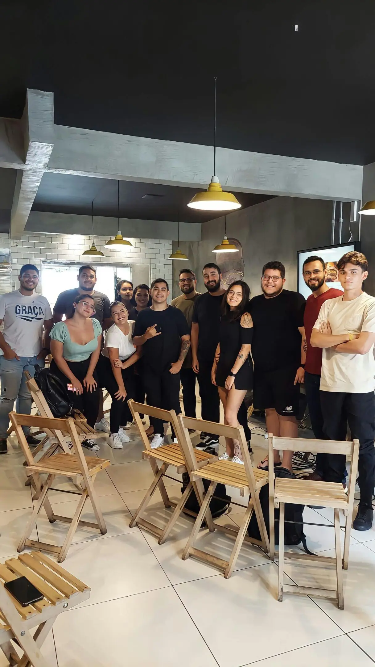 A group of people standing in front of chairs.